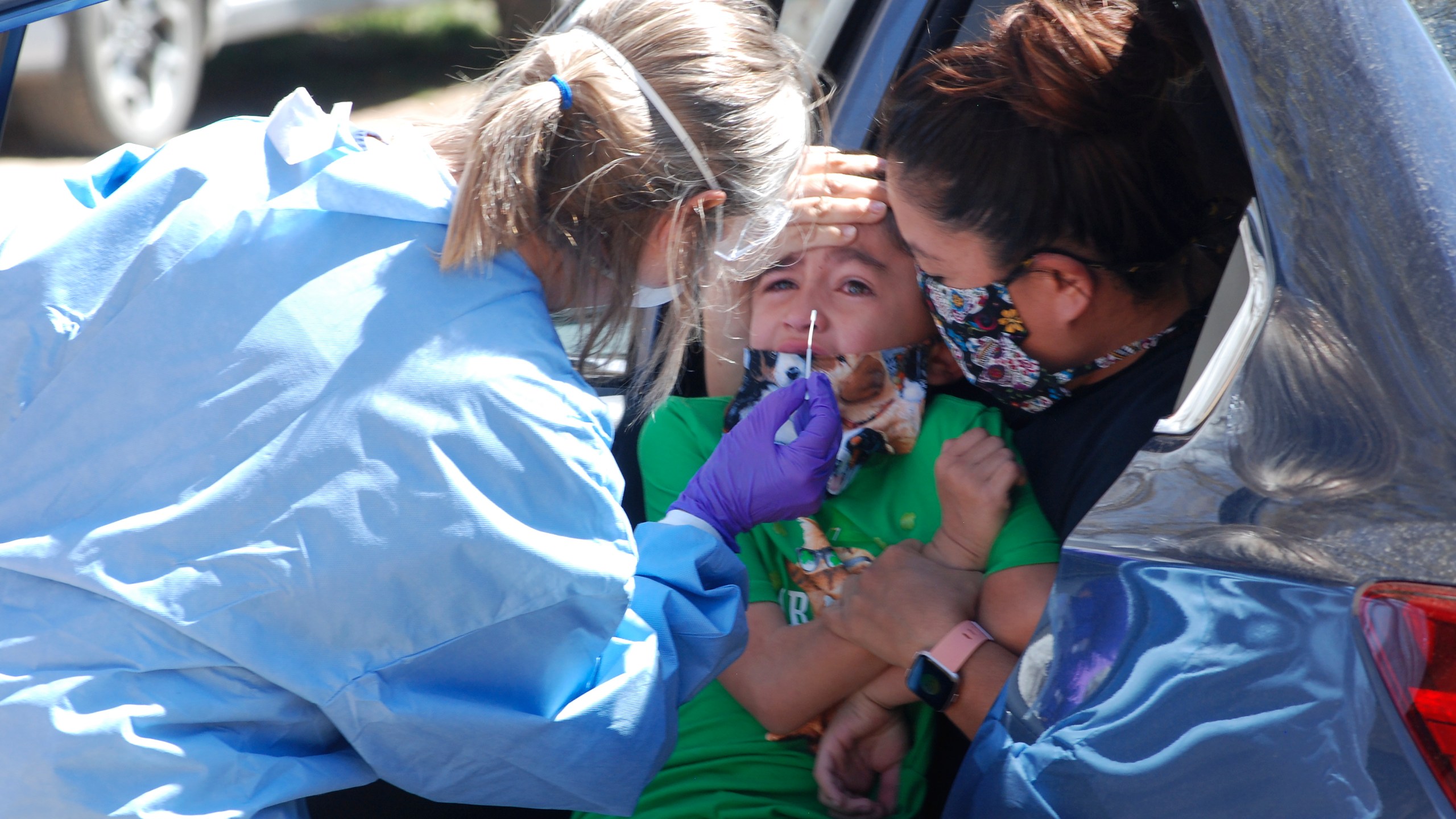 Ashley Pyne, right, helps her son, Elijah, complete a nasal swipe for COVID-19 testing in Picuris Pueblo, N.M., Thursday, April 24, 2020. Small Native American pueblo tribes across New Mexico are embracing extraordinary social distancing measures that include guarded roadblocks and universal testing for the coronavirus in efforts to insulate themselves from a contagion with frightening echoes of the past. (AP Photo/Morgan Lee)