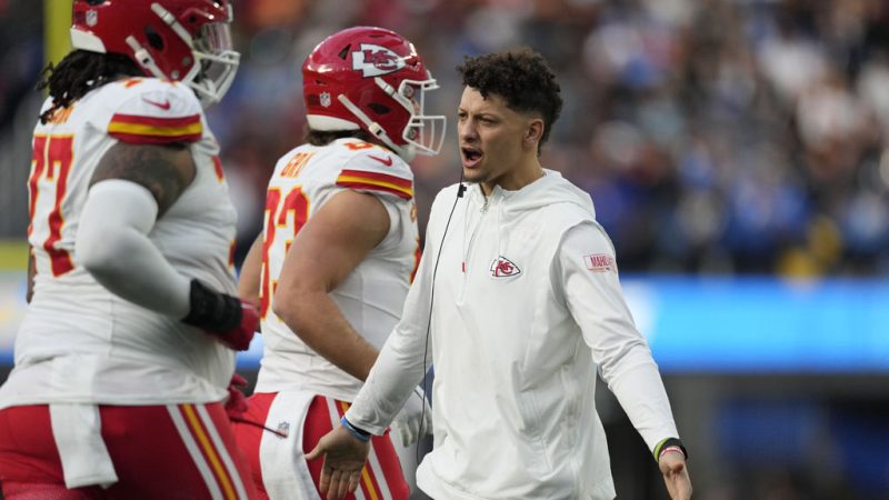 Kansas City Chiefs quarterback Patrick Mahomes, right, greets players on the sidelines during the first half of an NFL football game